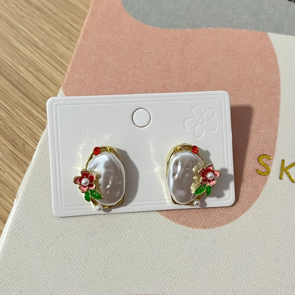 Aretes de piedra blanca con flores.